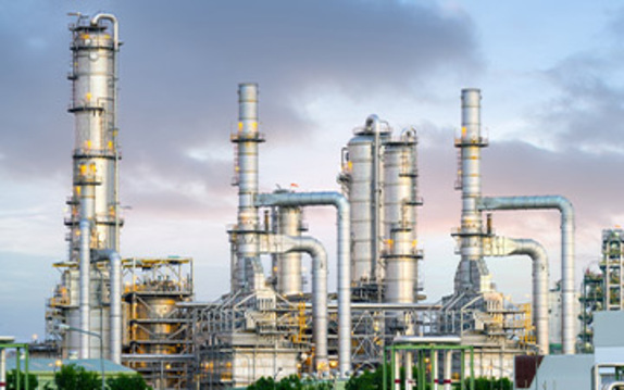 An oil refinery with a complex network of pipes and structures. A hub of activity in the oil industry.