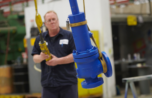 Worker testing an industrial valve in a valve repair facility