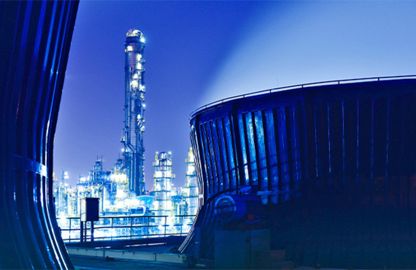IIoT asset management at work in a large crude oil refinery at night.