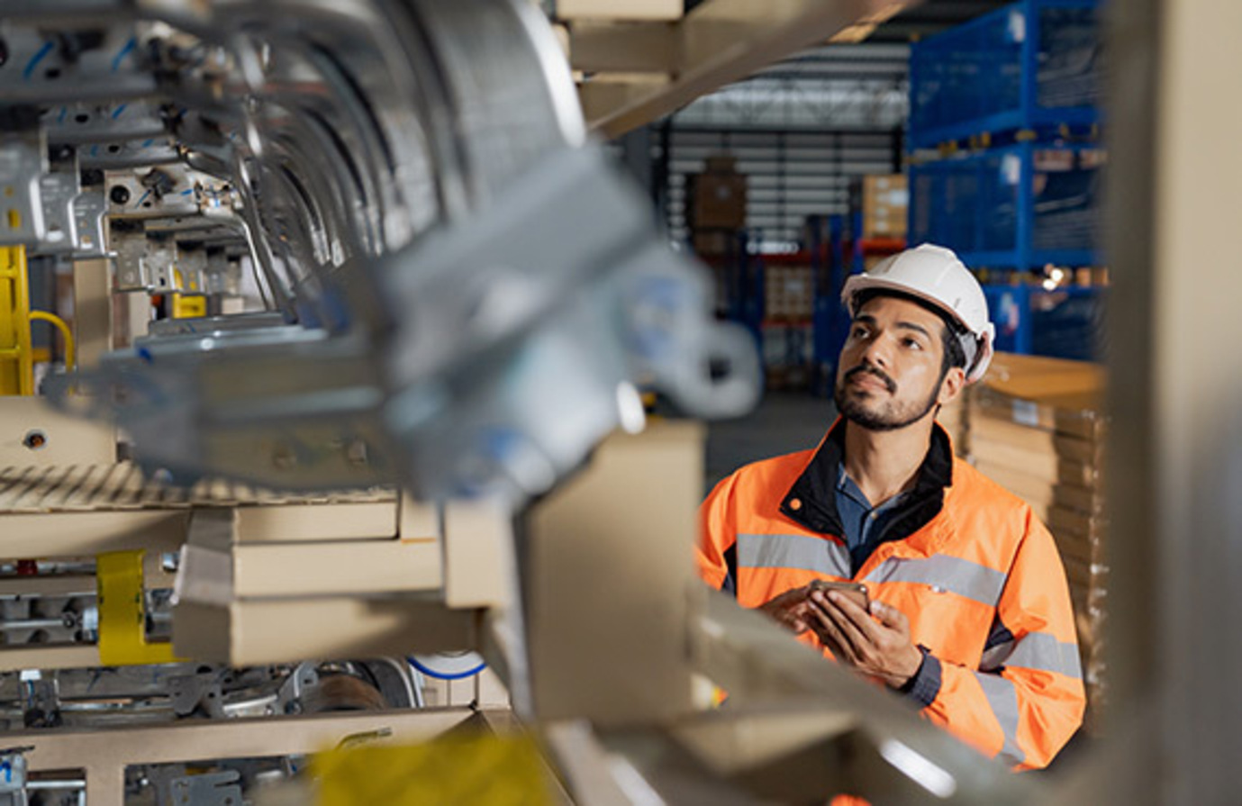 An employee in an industrial factory collecting data.