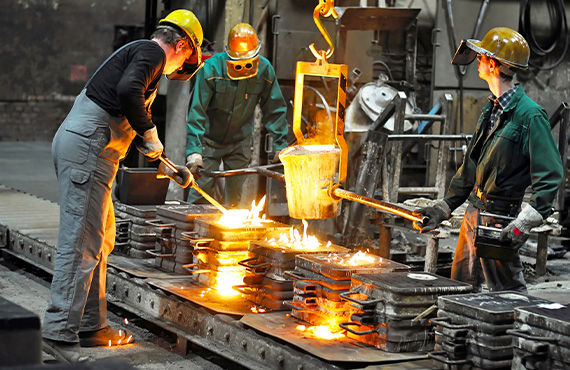 Metals industry workers in a foundry at the melting furnace.