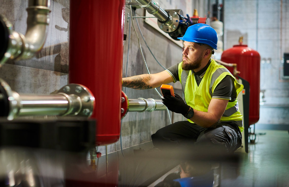 Power plant engineer testing connections during a shutdown The Risks of Unplanned<br>Plant Outages